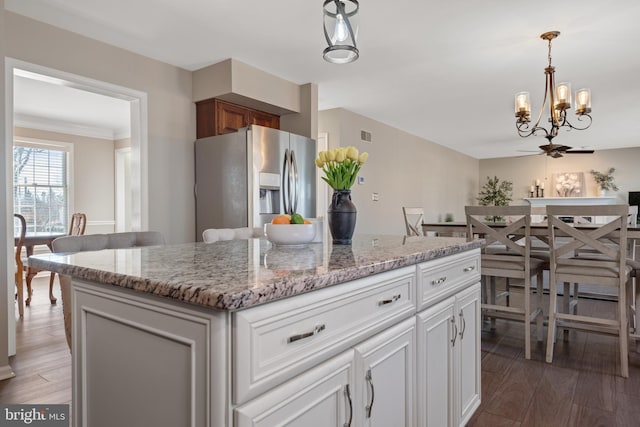 kitchen featuring pendant lighting, wood finished floors, stainless steel refrigerator with ice dispenser, and an inviting chandelier