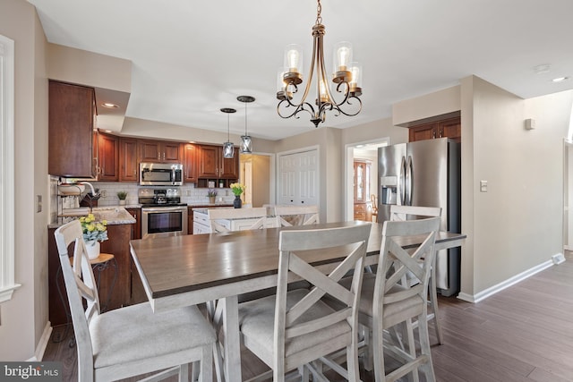 dining space featuring recessed lighting, wood finished floors, baseboards, and a chandelier