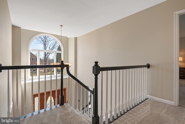 staircase with baseboards and carpet flooring