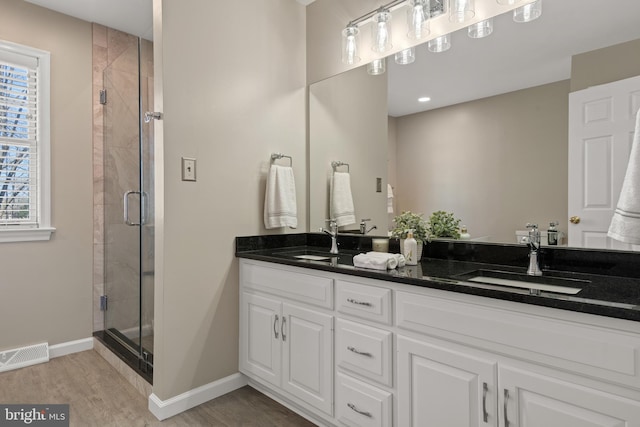 bathroom with visible vents, a shower stall, baseboards, and a sink