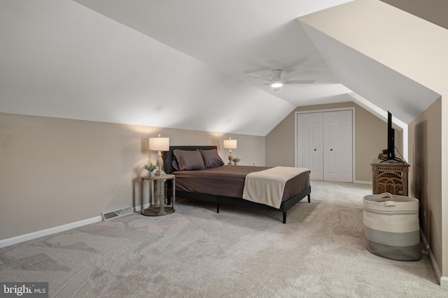 carpeted bedroom featuring a ceiling fan, baseboards, visible vents, lofted ceiling, and a closet