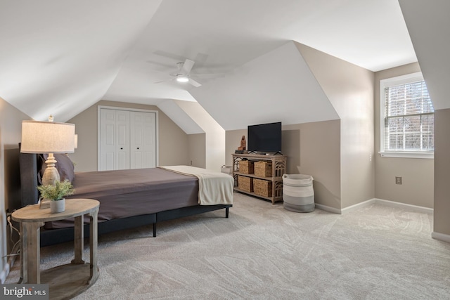 carpeted bedroom featuring a closet, ceiling fan, baseboards, and vaulted ceiling