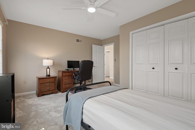 bedroom featuring a ceiling fan, visible vents, baseboards, a closet, and light colored carpet