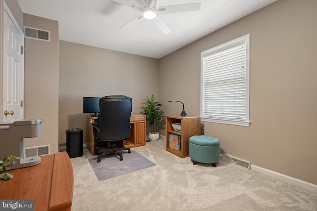 carpeted office space featuring visible vents, baseboards, and a ceiling fan