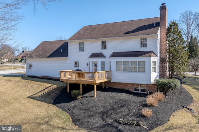 back of house with a yard, a chimney, and a deck