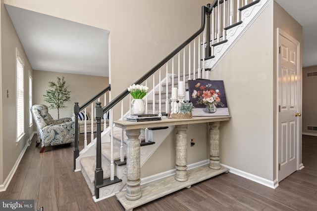 stairs with wood finished floors, visible vents, and baseboards