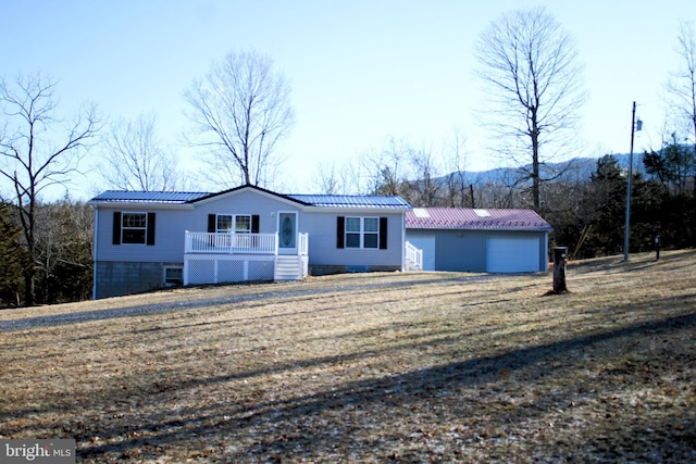 view of front of home featuring an attached garage, metal roof, and an outdoor structure