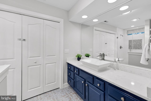 bathroom with recessed lighting, a closet, tiled shower, and vanity
