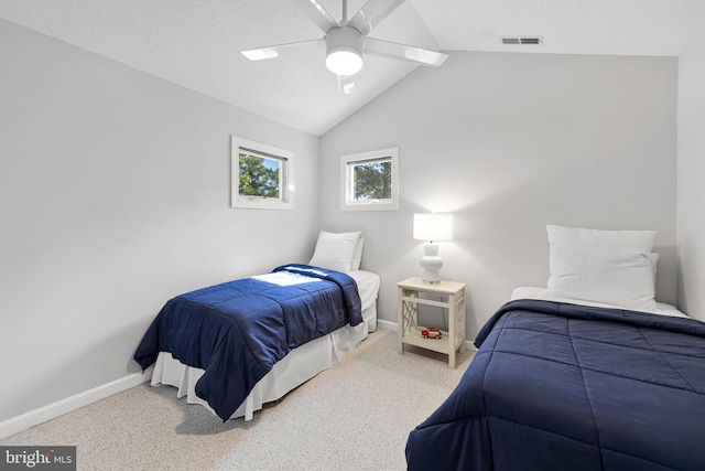 carpeted bedroom featuring vaulted ceiling, a ceiling fan, a textured ceiling, baseboards, and visible vents