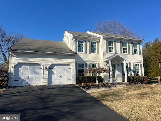 colonial-style house with a garage and aphalt driveway