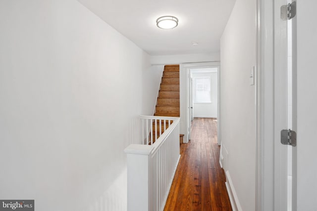 hallway with baseboards and hardwood / wood-style flooring