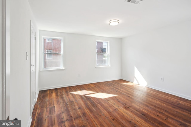 spare room with visible vents, baseboards, and hardwood / wood-style floors