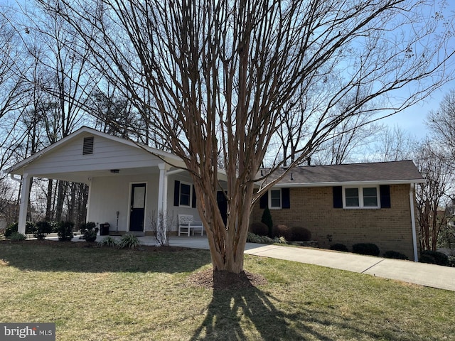 ranch-style house with brick siding, covered porch, and a front yard