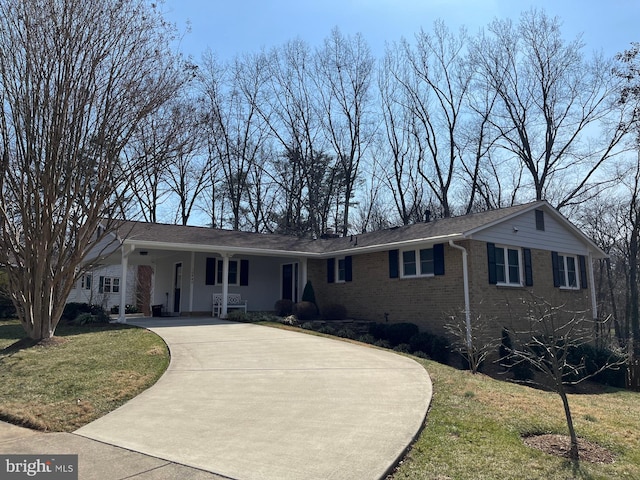 ranch-style home with concrete driveway, brick siding, and a front lawn