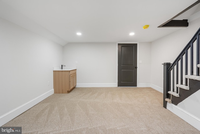 finished below grade area featuring recessed lighting, light colored carpet, stairway, and baseboards