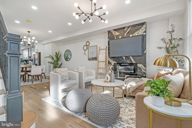 living room with recessed lighting, light wood-type flooring, and a notable chandelier