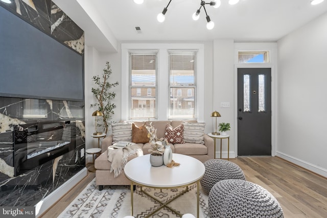 living area with wood finished floors, visible vents, and baseboards