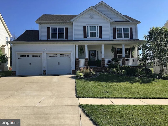 view of front of house with a porch, a garage, brick siding, driveway, and a front lawn