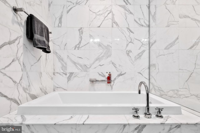 bathroom with a tub with marble appearance