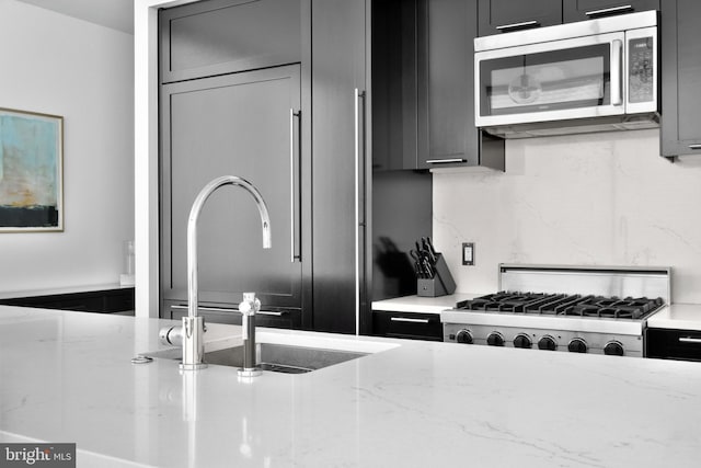 kitchen featuring stainless steel microwave, gray cabinetry, and stove