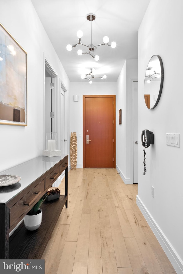 hallway featuring light wood-type flooring and baseboards