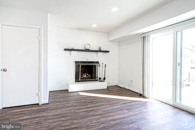 unfurnished living room with baseboards, a fireplace, wood finished floors, and recessed lighting