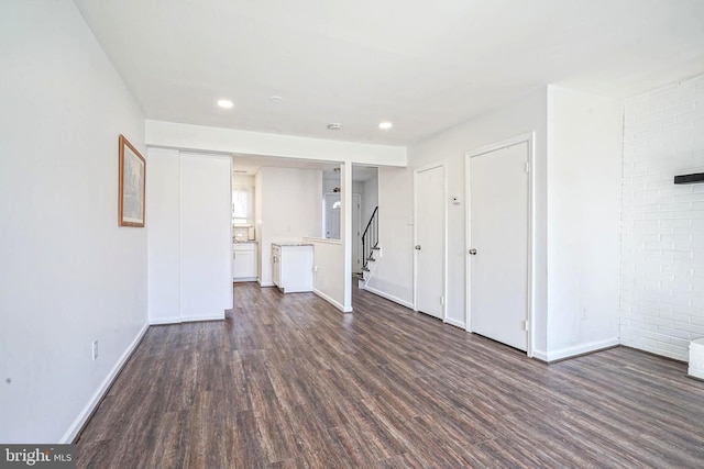 interior space with dark wood-style floors, recessed lighting, stairway, and baseboards