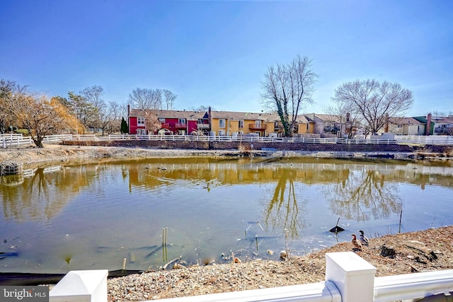 view of water feature with a residential view and fence