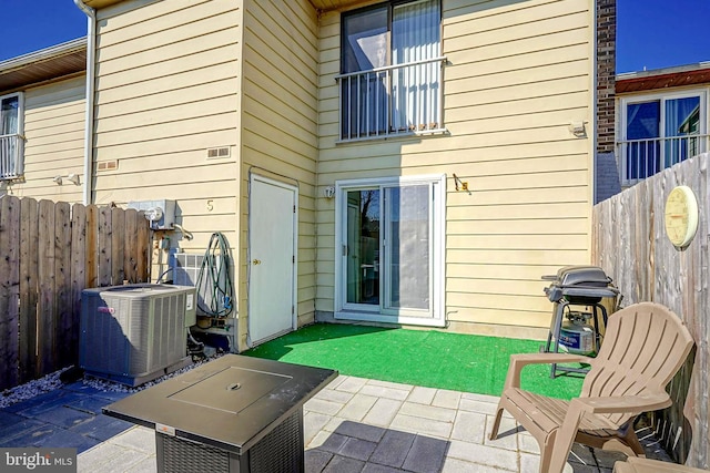 rear view of house with central AC, a patio, and fence