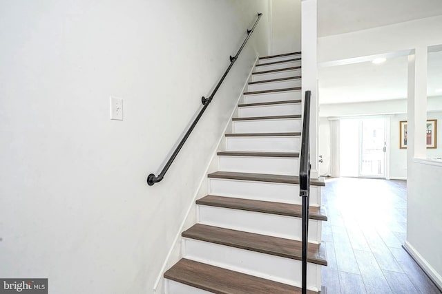 staircase with wood finished floors and baseboards