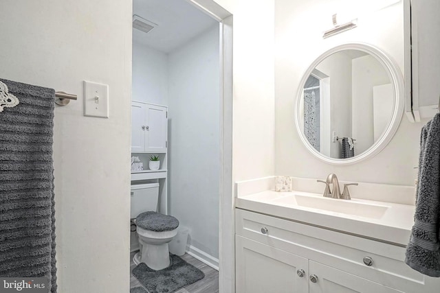 bathroom with toilet, visible vents, and vanity