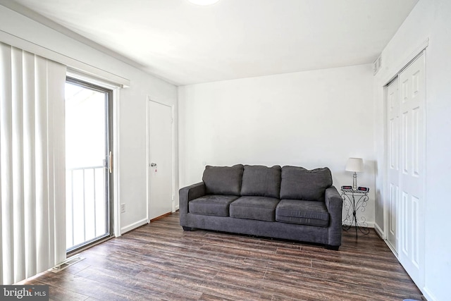 living room with visible vents, baseboards, and wood finished floors