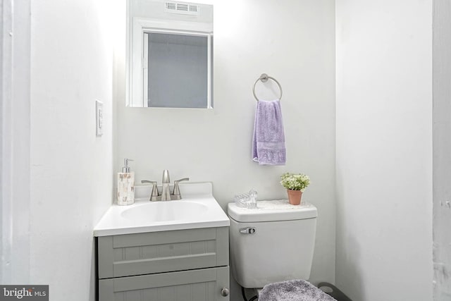 bathroom featuring toilet, visible vents, and vanity