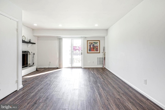 unfurnished living room with dark wood-style floors, recessed lighting, a fireplace, and baseboards