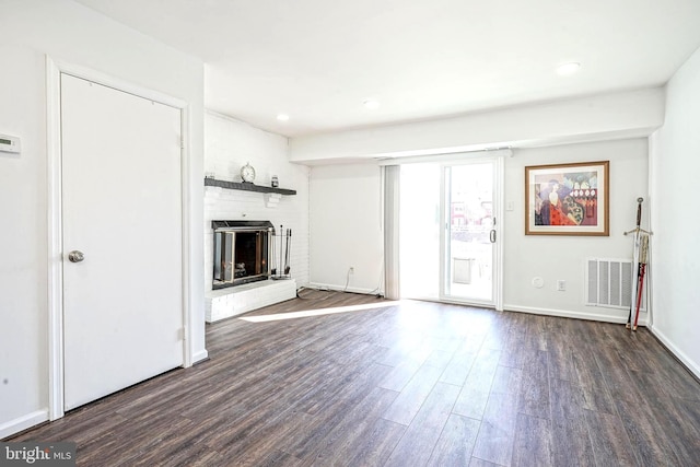 unfurnished living room with baseboards, visible vents, wood finished floors, a fireplace, and recessed lighting