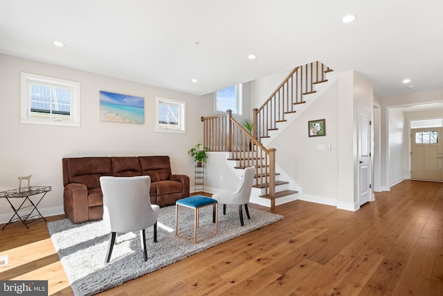 living area featuring hardwood / wood-style flooring, stairway, recessed lighting, and baseboards