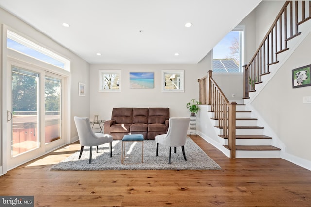 living room featuring hardwood / wood-style floors, stairs, recessed lighting, and baseboards