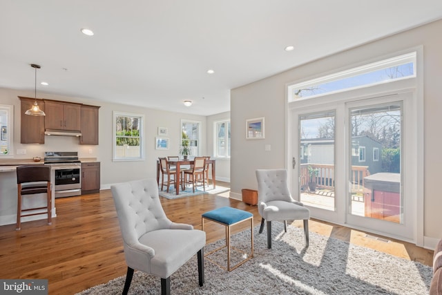 living area featuring recessed lighting, baseboards, and light wood-style flooring