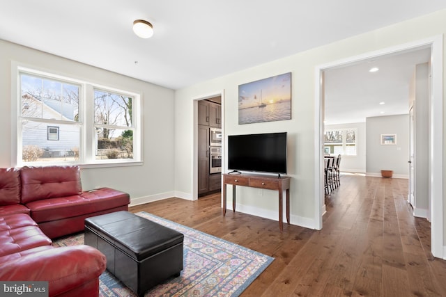 living room featuring recessed lighting, baseboards, and wood-type flooring