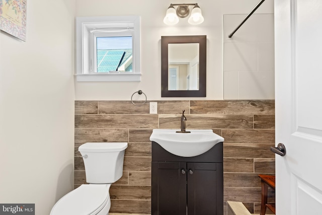 bathroom featuring a wainscoted wall, toilet, and vanity