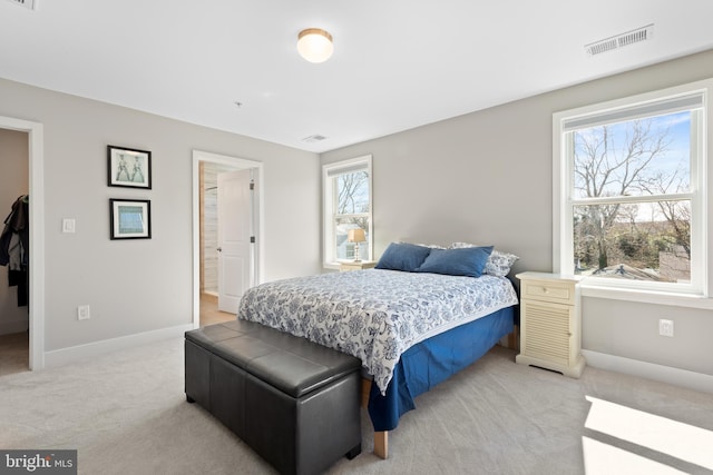 bedroom with visible vents, light colored carpet, and baseboards