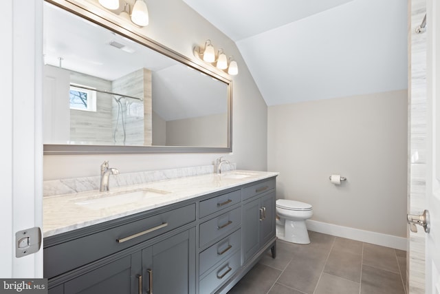 bathroom featuring tile patterned floors, vaulted ceiling, baseboards, and a sink