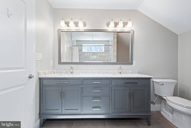 full bathroom with tile patterned floors, toilet, lofted ceiling, and a sink