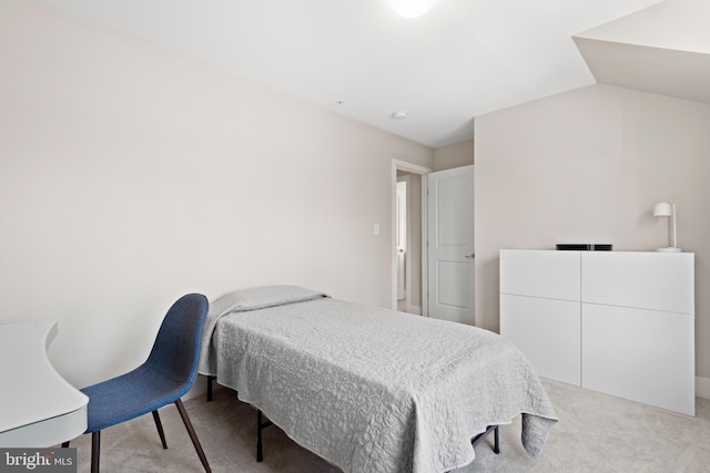 carpeted bedroom with lofted ceiling