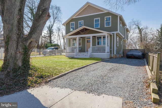 view of front of house featuring gravel driveway, a front lawn, a porch, and fence