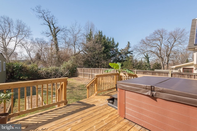 wooden terrace featuring a hot tub and a fenced backyard