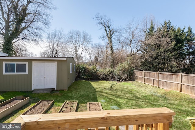 view of yard featuring an outbuilding, a vegetable garden, and fence