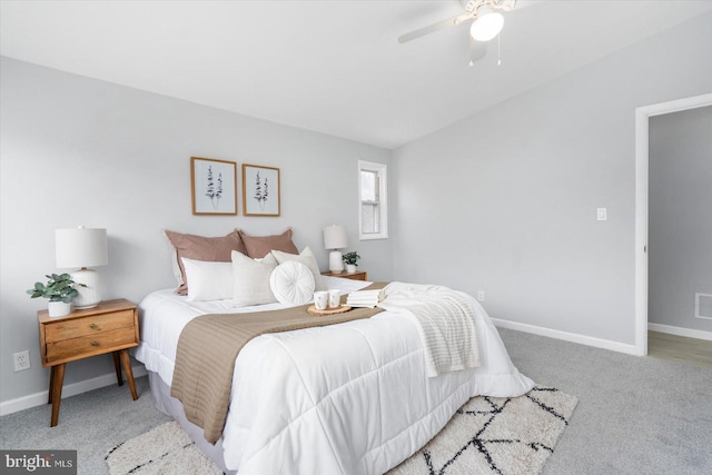 carpeted bedroom featuring a ceiling fan, lofted ceiling, visible vents, and baseboards