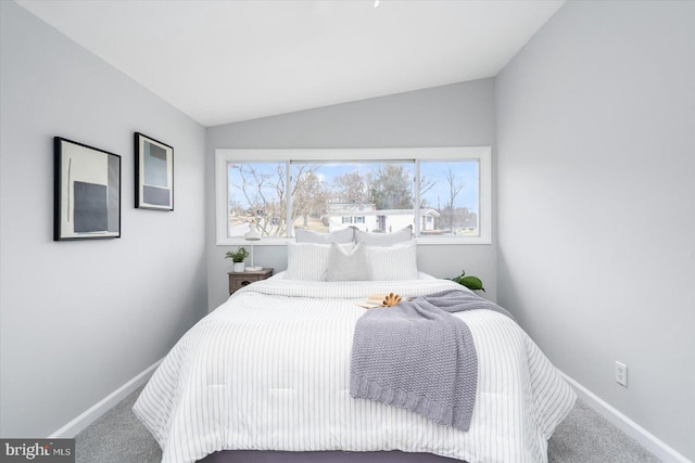 bedroom featuring lofted ceiling, baseboards, and carpet flooring