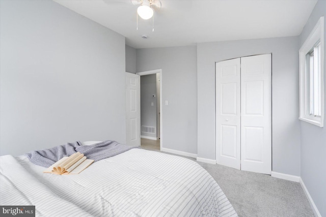 bedroom with carpet floors, a closet, visible vents, and baseboards